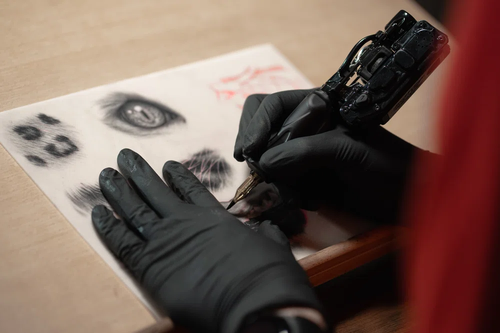Artiste tatoueur pratiquant sur une peau synthétique