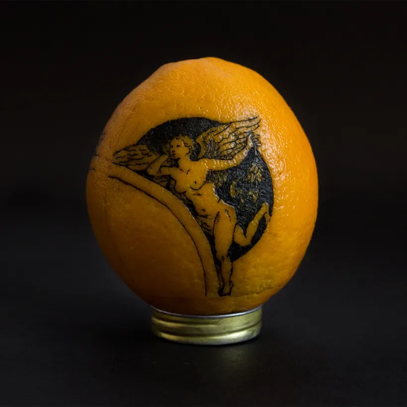 tatuaje realizado sobre la piel de una naranja